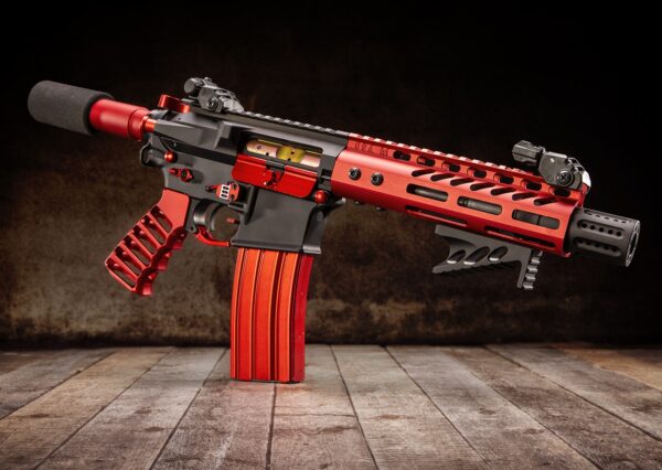 a red and black machine gun on a wooden floor