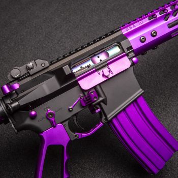 a purple and black rifle on a black background