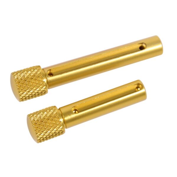 a pair of gold toned metal screws on a white background
