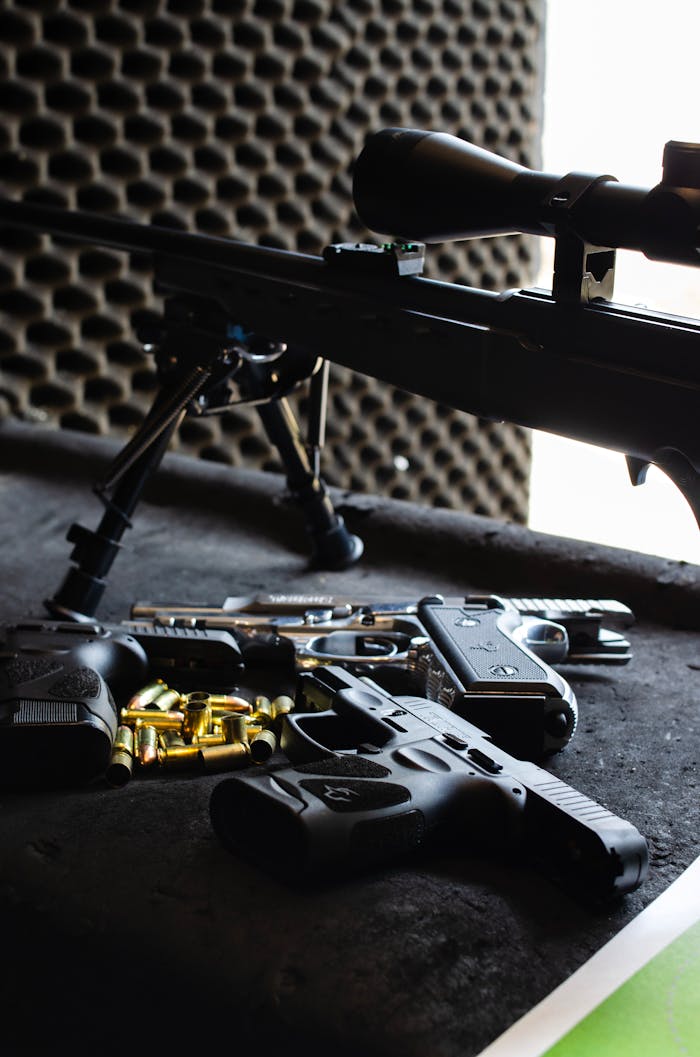 Close-up of various firearms and ammunition on a shooting range table in São Paulo, Brazil.